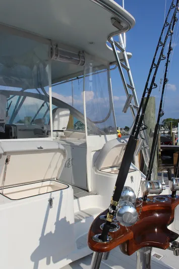  Yacht Photos Pics 2005 Cabo 40 Hardtop Express yacht with fishing rods, docked under clear blue sky.