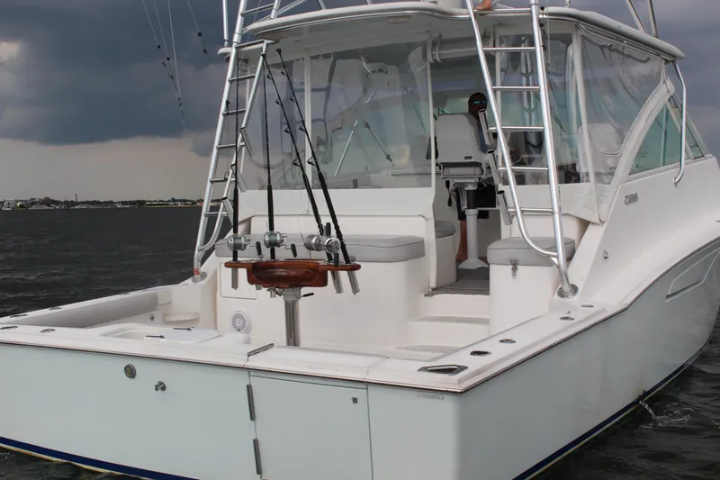  Yacht Photos Pics 2005 Cabo 40 Hardtop Express boat on water, featuring fishing rods and stormy sky.