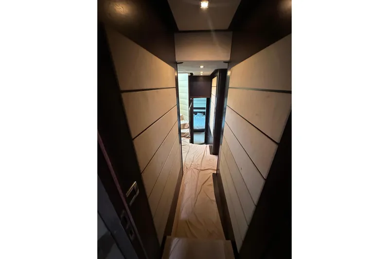 Romeo & Juliet Yacht Photos Pics Narrow hallway inside 2009 Azimut 86S yacht, featuring modern wood paneling and soft lighting.