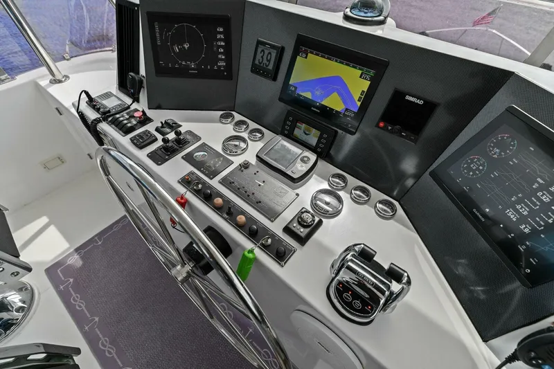 Sunshine And Happiness Yacht Photos Pics Boat control panel with navigation screens, steering wheel, and various instruments.