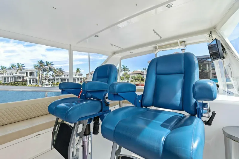 Sunshine And Happiness Yacht Photos Pics Luxurious boat interior with blue captain chairs and waterfront view.
