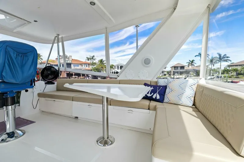 Sunshine And Happiness Yacht Photos Pics Luxurious yacht interior with beige seating, table, and scenic marina view.