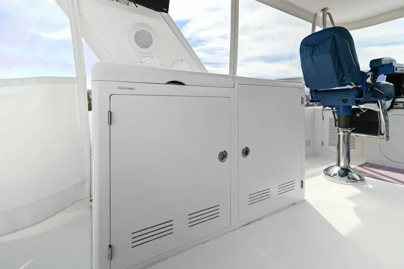 Sunshine And Happiness Yacht Photos Pics White boat interior with storage cabinets and a blue captain's chair.