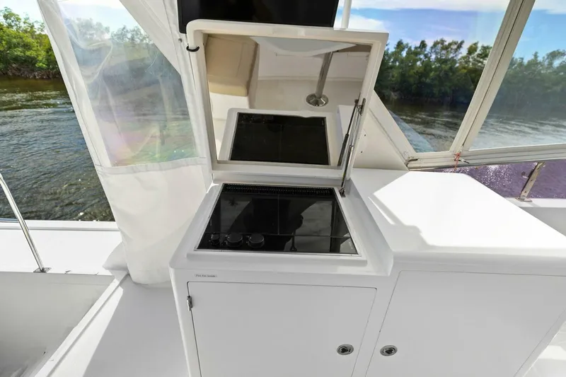 Sunshine And Happiness Yacht Photos Pics Boat kitchen area with stove, open hatch, and river view.