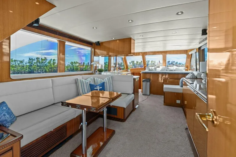 Sunshine And Happiness Yacht Photos Pics Luxurious yacht interior with plush seating, wooden accents, and large windows offering scenic views.