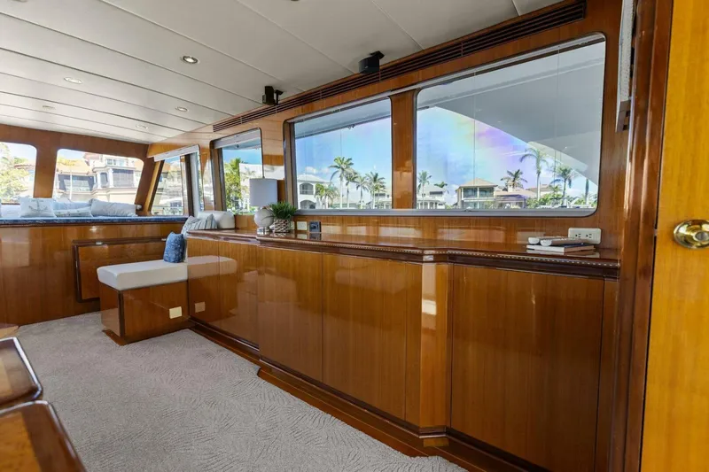 Sunshine And Happiness Yacht Photos Pics Luxurious yacht interior with wooden paneling and large windows, showcasing a serene waterfront view.