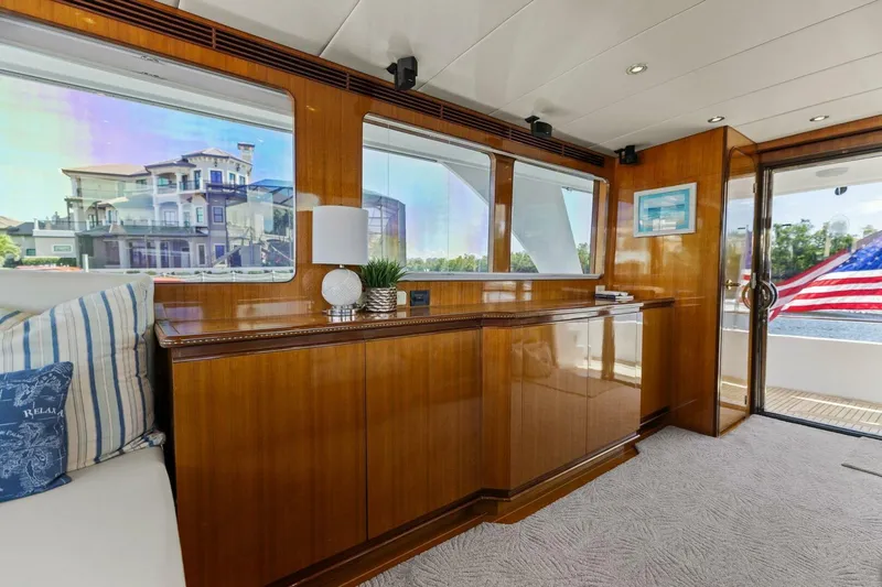 Sunshine And Happiness Yacht Photos Pics Luxurious yacht interior with wooden cabinetry, large windows, and American flag view.