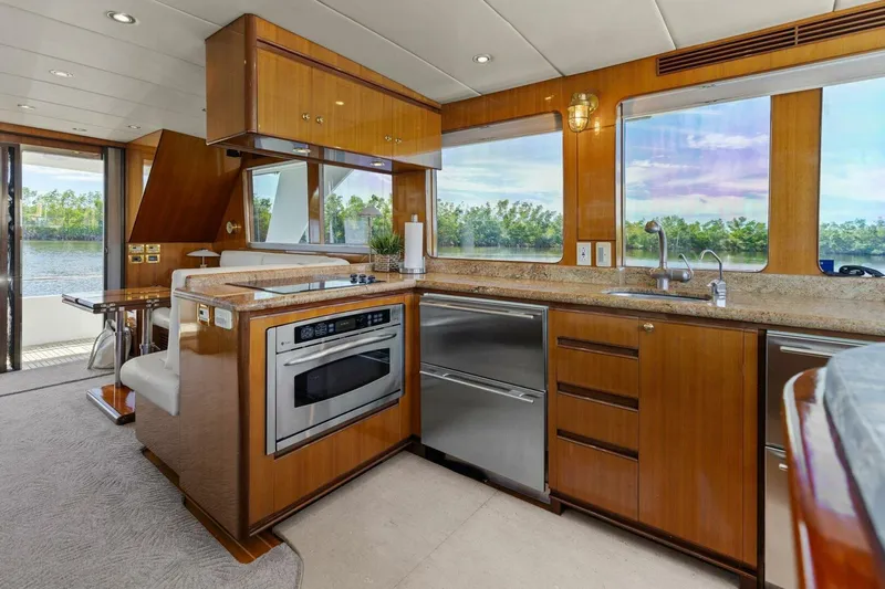 Sunshine And Happiness Yacht Photos Pics Luxurious yacht kitchen with modern appliances, wooden cabinetry, and scenic water views.