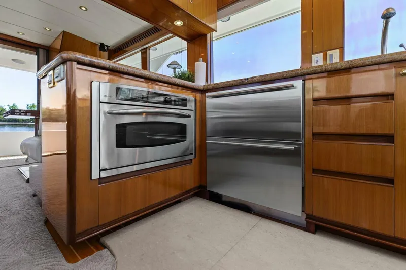 Sunshine And Happiness Yacht Photos Pics Modern yacht kitchen with stainless steel appliances and wooden cabinetry.