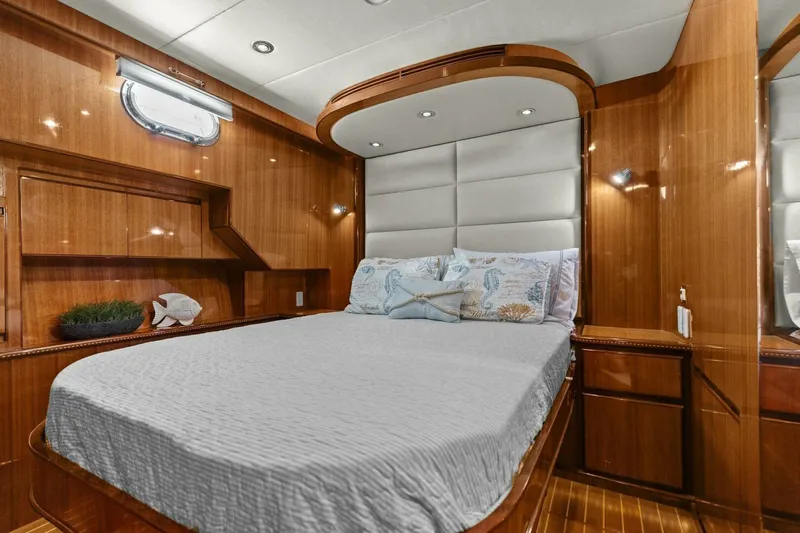 Sunshine And Happiness Yacht Photos Pics Luxurious yacht bedroom with wooden interior, plush bedding, and ambient lighting.