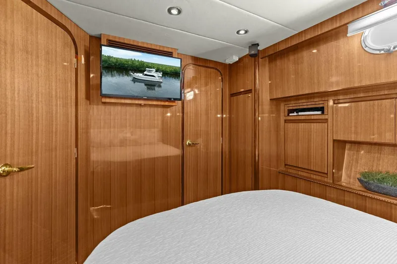 Sunshine And Happiness Yacht Photos Pics Luxurious wooden interior with TV and bed in a yacht cabin.