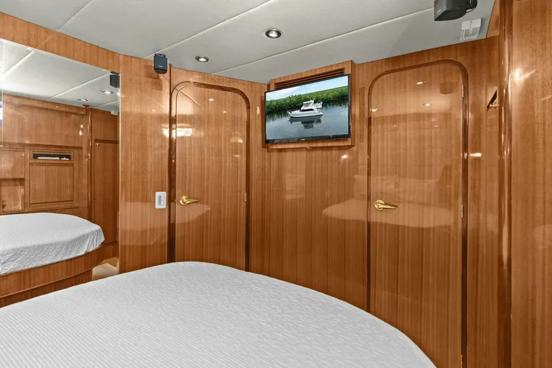 Sunshine And Happiness Yacht Photos Pics Luxurious yacht cabin with wood paneling, bed, and wall-mounted TV.