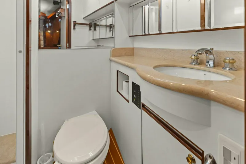 Sunshine And Happiness Yacht Photos Pics Compact bathroom with white fixtures, wooden accents, and mirrored cabinets.