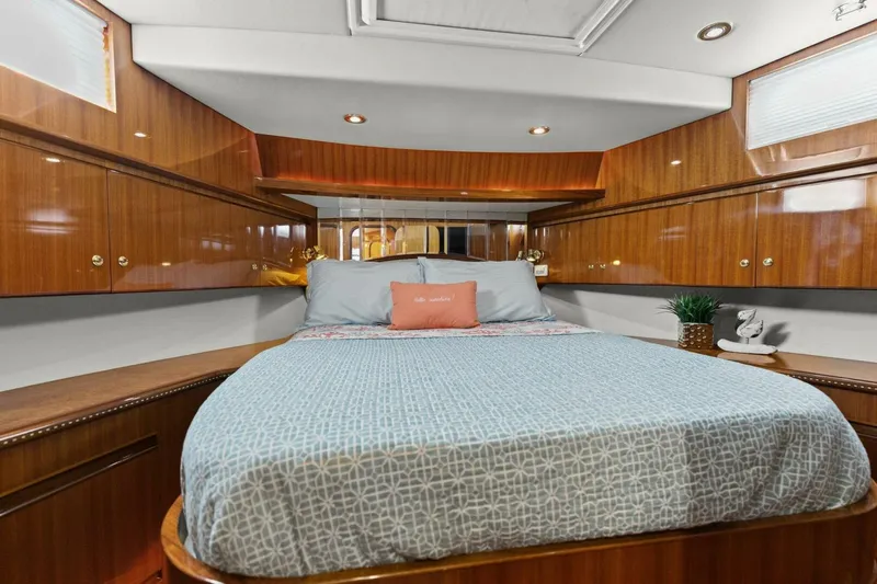 Sunshine And Happiness Yacht Photos Pics Luxurious yacht bedroom with wood paneling, cozy bedding, and ambient lighting.