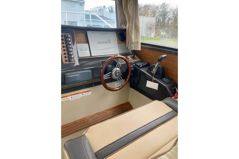  Yacht Photos Pics 2018 Ranger Tugs R-27 helm with Garmin navigation, wooden steering wheel, and control panel.