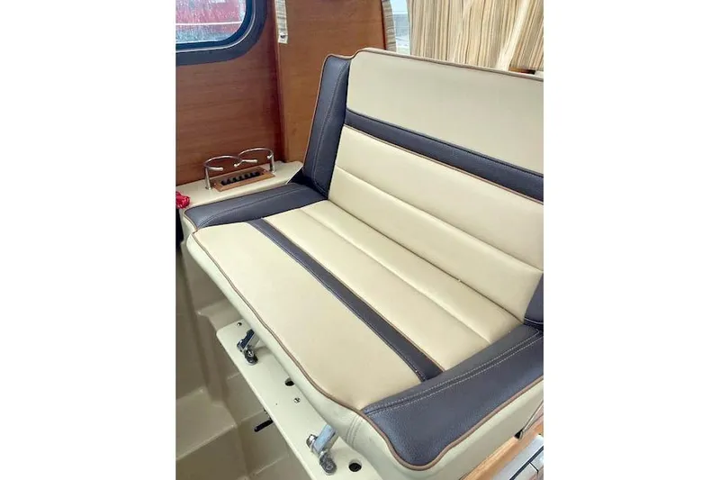  Yacht Photos Pics 2018 Ranger Tugs R-27 interior seat with beige and dark trim, wooden accents.