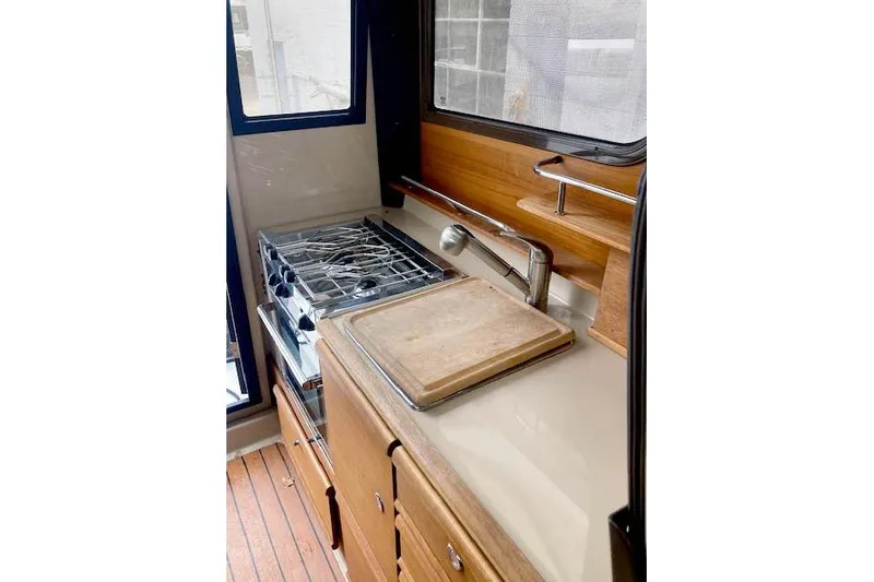  Yacht Photos Pics 2018 Ranger Tugs R-27 boat kitchen with stove, sink, and cutting board.
