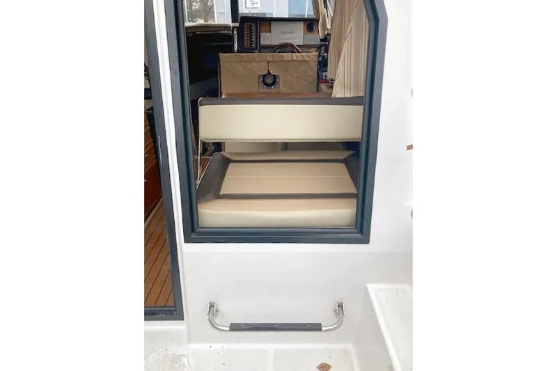  Yacht Photos Pics 2018 Ranger Tugs R-27 interior view with beige seating and control panel.