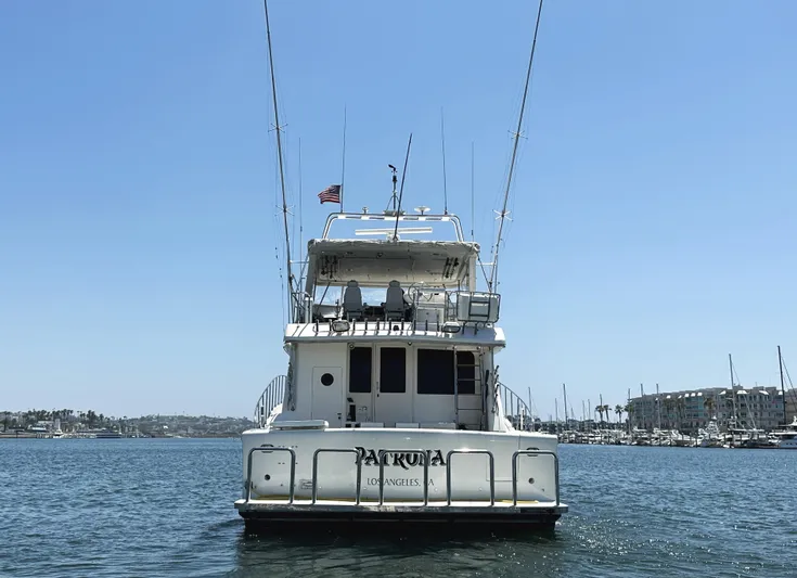 Patrona Yacht Photos Pics Mikelson 61 Sportfisher 2000 yacht on water, rear view, clear sky, marina background.