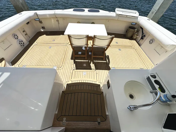 Patrona Yacht Photos Pics Spacious deck of 2000 Mikelson 61 Sportfisher with seating and table, overlooking water.