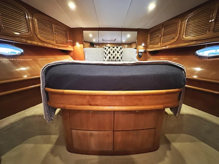 Patrona Yacht Photos Pics Luxurious cabin interior of 2000 Mikelson 61 Sportfisher with wooden cabinetry and cozy bedding.