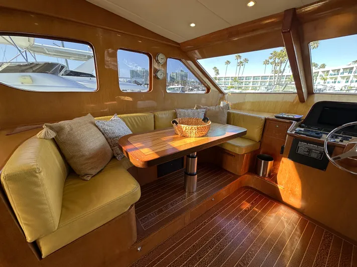 Patrona Yacht Photos Pics Luxurious interior of 2000 Mikelson 61 Sportfisher yacht with plush seating and wooden table.