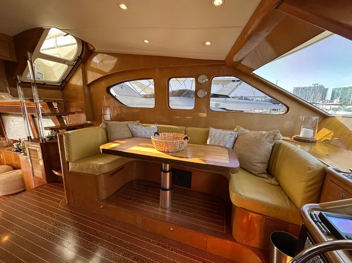 Patrona Yacht Photos Pics Luxurious interior of 2000 Mikelson 61 Sportfisher yacht with cozy seating and wooden accents.