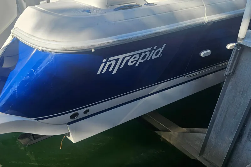  Yacht Photos Pics 2015 Intrepid 327 Center Console boat docked, featuring a sleek blue and white design.