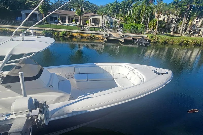  Yacht Photos Pics 2015 Intrepid 327 Center Console boat docked by a scenic waterfront.