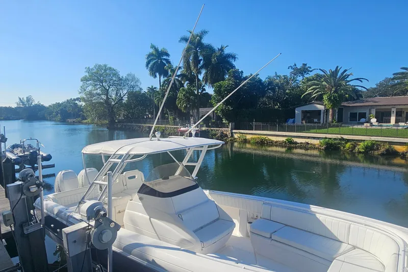  Yacht Photos Pics 2015 Intrepid 327 Center Console boat docked by a scenic waterfront with palm trees.