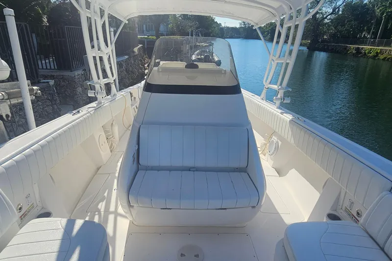  Yacht Photos Pics 2015 Intrepid 327 Center Console boat interior with seating, docked by a serene waterway.