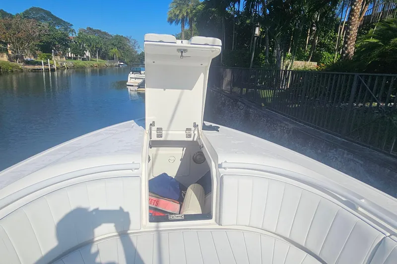  Yacht Photos Pics 2015 Intrepid 327 Center Console boat with open storage compartment on a sunny day.