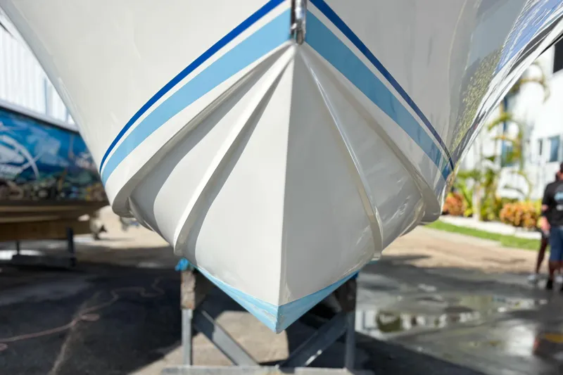  Yacht Photos Pics Close-up of a 2016 Whitewater boat hull with blue stripes, displayed outdoors.