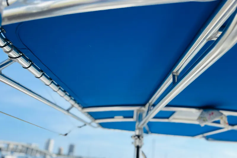  Yacht Photos Pics Blue boat canopy with metal frame, Whitewater make, 2016 model, clear sky background.