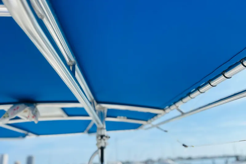  Yacht Photos Pics Blue boat canopy with metal frame, Whitewater make, 2016 model, clear sky background.
