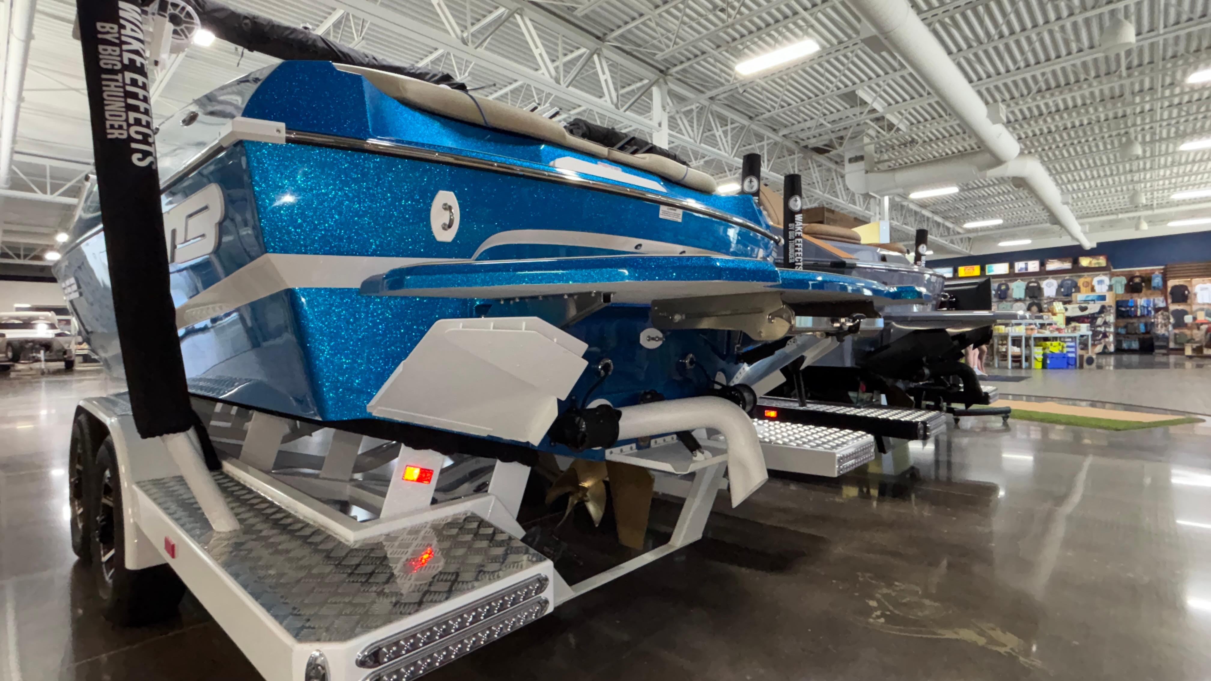 2025 MB B52 23 Classic boat in showroom, blue glitter finish, on trailer.