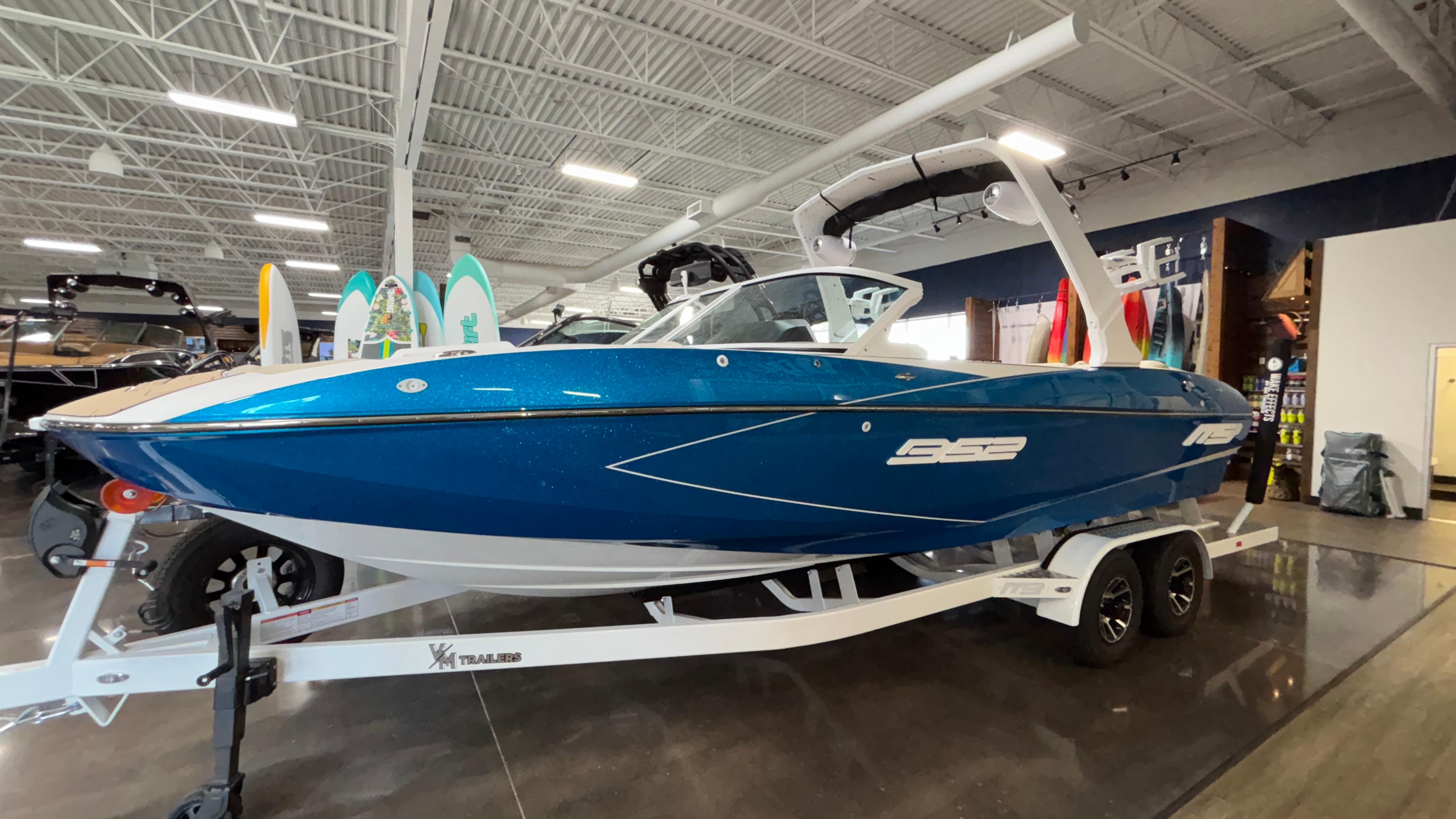 2025 MB B52 23 Classic boat in showroom, blue exterior, on a trailer.