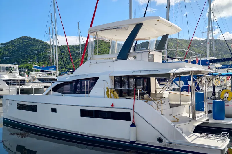High Life Yacht Photos Pics 2020 Leopard 43 Powercat yacht docked in a marina with scenic mountain backdrop.
