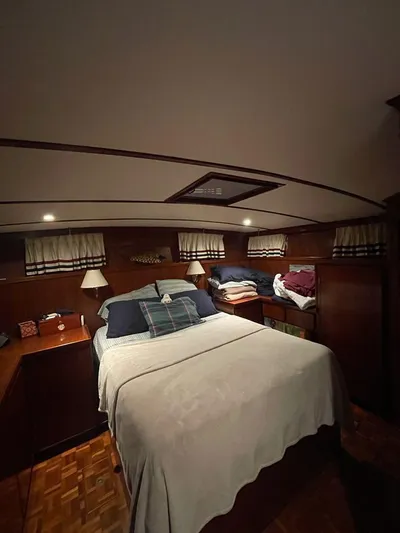  Yacht Photos Pics Cozy bedroom interior of 1983 Sea Ranger 45 Sundeck yacht with wood paneling and ambient lighting.