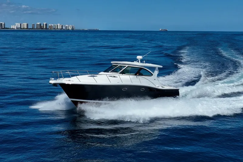 Blue Pearl Yacht Photos Pics 2004 Tiara Yachts 4200 Open cruising on blue ocean with city skyline in background.