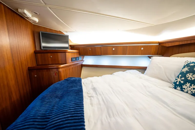 Blue Pearl Yacht Photos Pics Luxurious cabin interior of 2004 Tiara Yachts 4200 Open with wood paneling and cozy bedding.