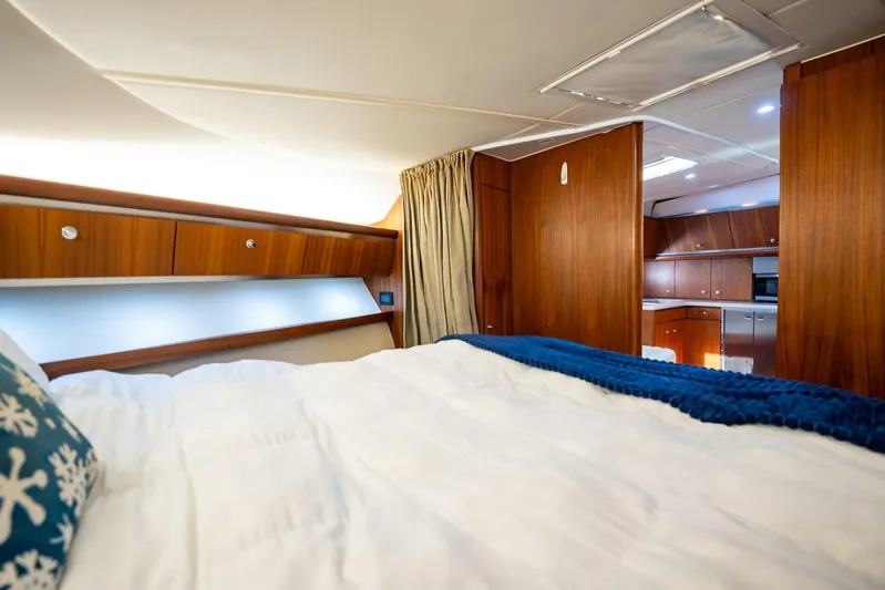 Blue Pearl Yacht Photos Pics Luxurious interior of 2004 Tiara Yachts 4200 Open, featuring cozy bedroom and elegant wood finishes.