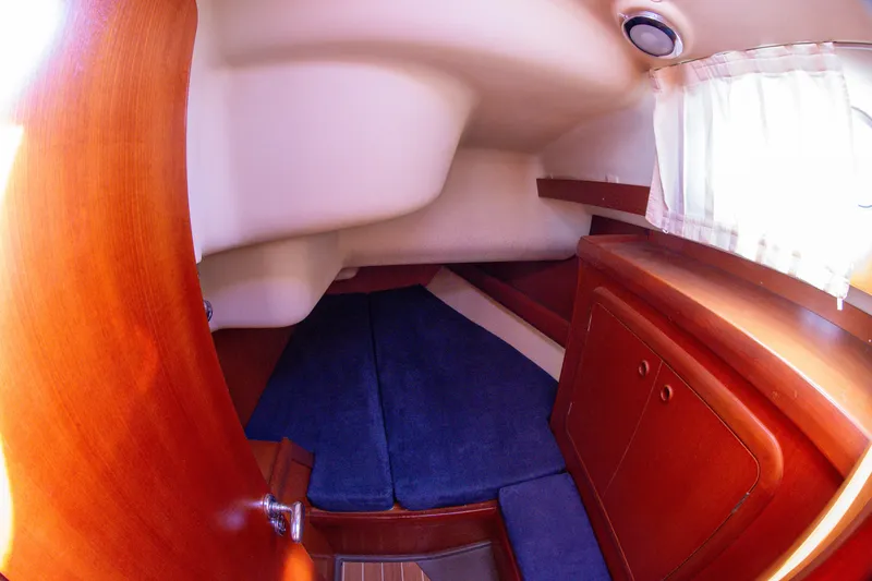  Yacht Photos Pics Interior cabin of 2005 Grand Soleil 43 yacht with wooden finish and blue cushions.