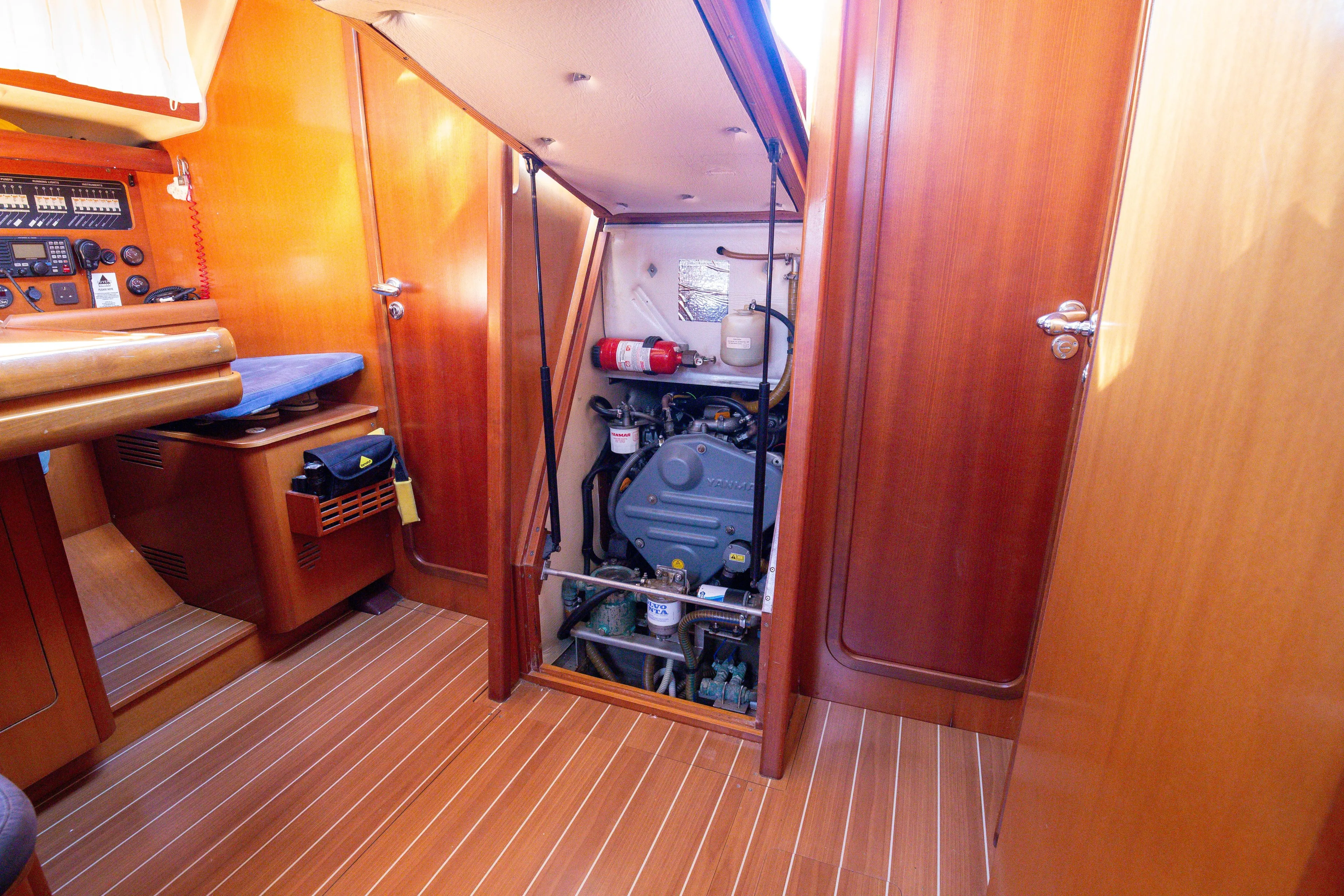  Yacht Photos Pics Engine room of 2005 Grand Soleil 43 sailboat with wooden interior and visible engine.
