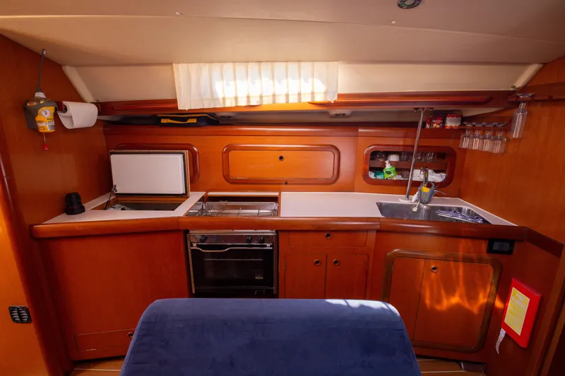  Yacht Photos Pics Interior of 2005 Grand Soleil 43 yacht kitchen with wooden cabinetry and modern amenities.