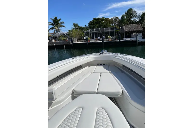  Yacht Photos Pics 2019 HCB 42 Siesta boat with cushioned seating, docked near palm trees.