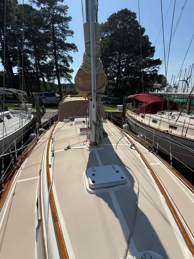 Moonsplash Yacht Photos Pics 1987 Island Packet 38 sailboat deck with mast, docked among trees and other boats.