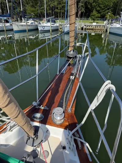 Moonsplash Yacht Photos Pics Bow of 1987 Island Packet 38 sailboat docked in a marina, showing anchor chain and railing.