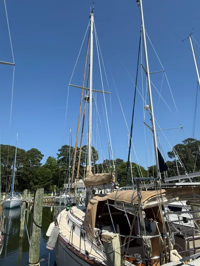 Moonsplash Yacht Photos Pics 1987 Island Packet 38 sailboat docked in a marina, surrounded by trees and clear blue sky.