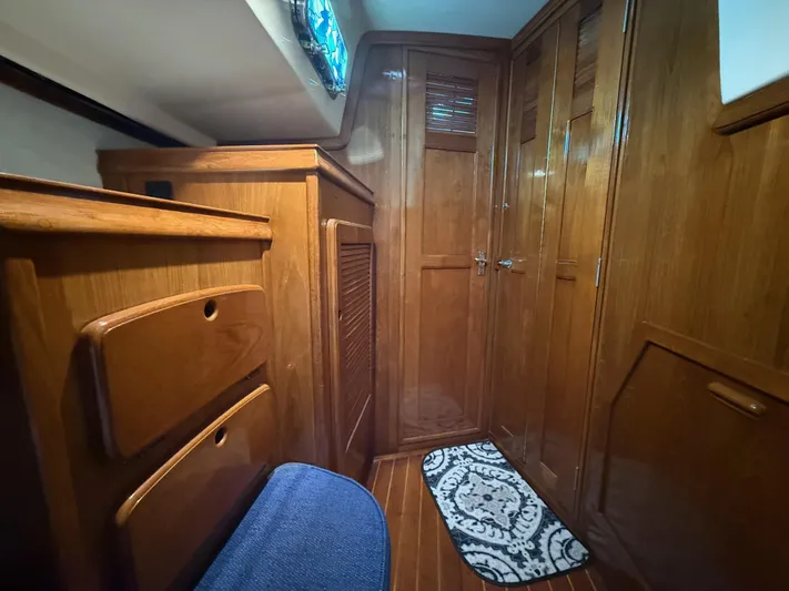 Moonsplash Yacht Photos Pics Interior of 1987 Island Packet 38 sailboat with wooden cabinetry and blue cushioned seating.